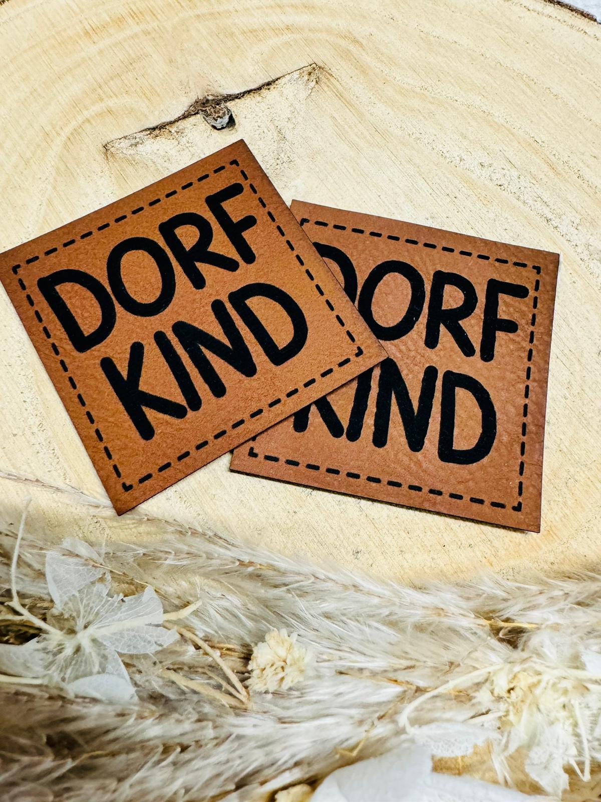 braunes kunstlederlabel mit dem spruch dorfkind