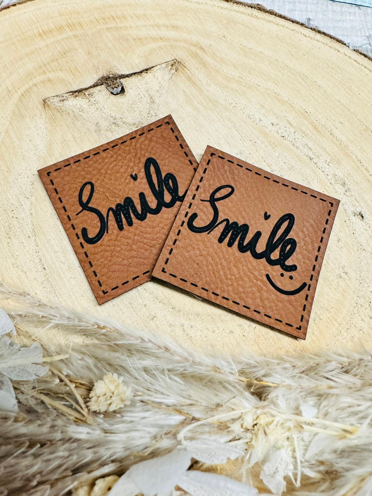 braunes christmas kunstlederlabel mit dem spruch smile und einem smiley
