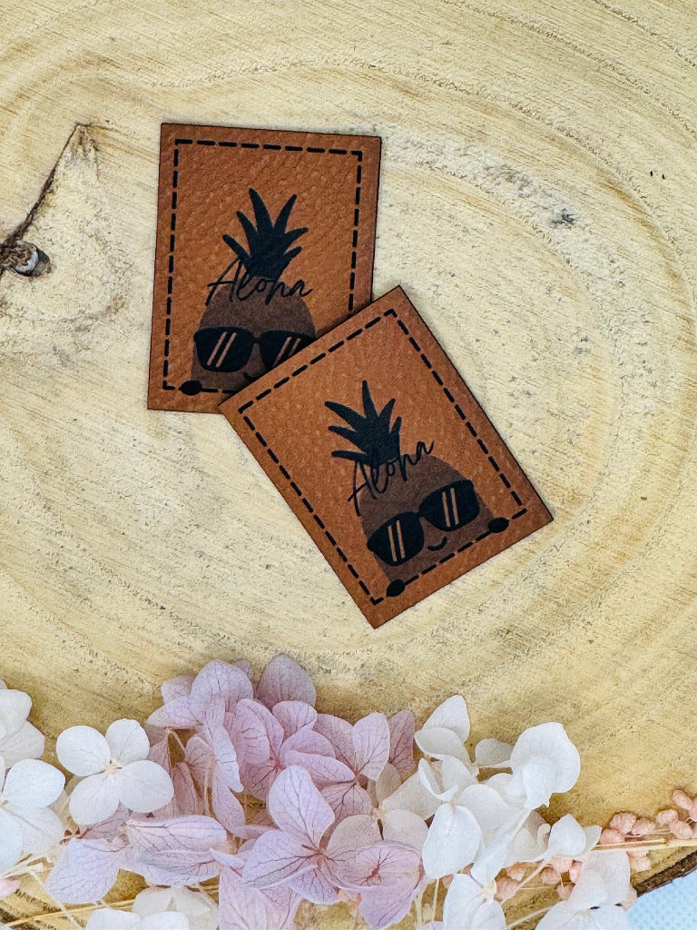 superweiches braunes Kunstlederlabel mit einer coolen Ananas und dem Spruch Aloha abgebildet