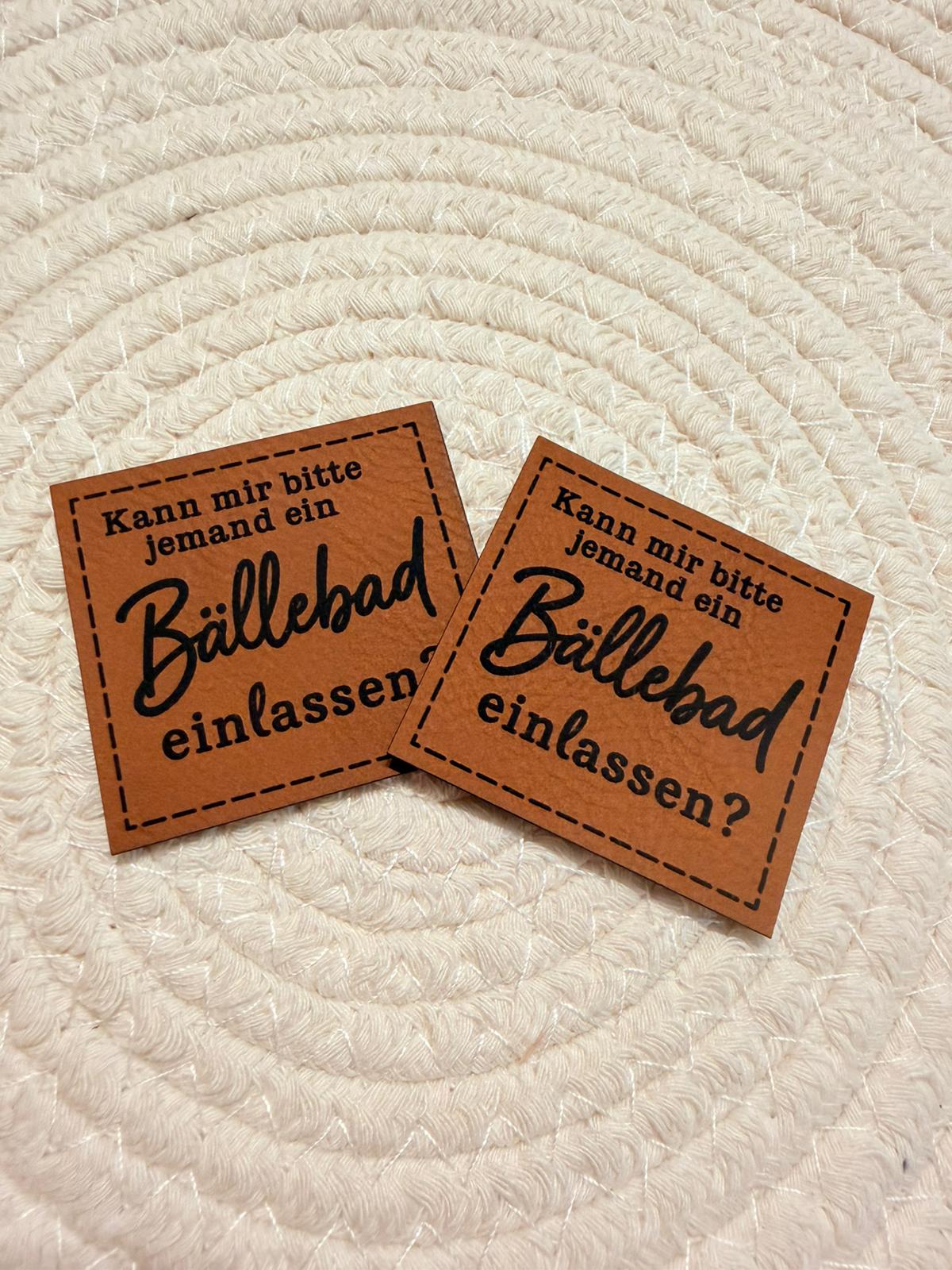 superweiches braunes Kunstlederlabel mit dem Spruch Kann mir bitte jemand ein Bällebad einlassen?
