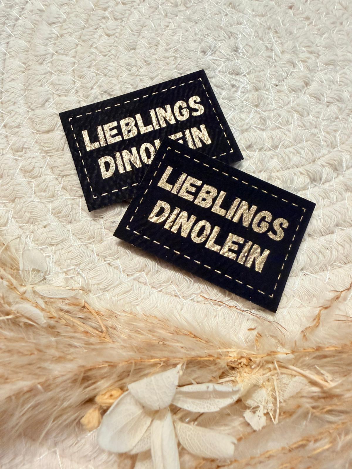 superweiches schwarzes Kunstlederlabel mit dem Spruch Lieblings Dinolein in goldenen Buchstaben