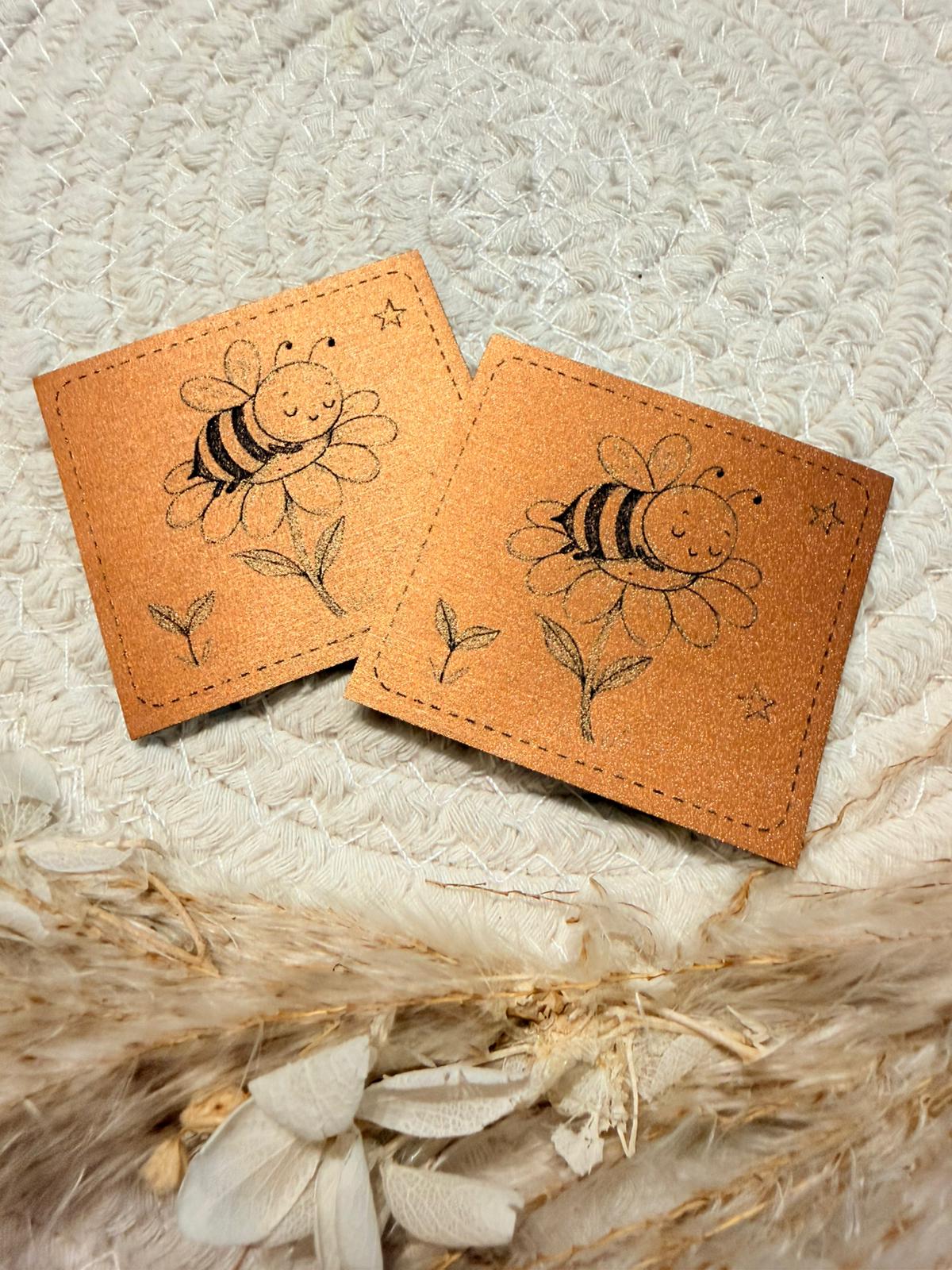 superweiches bronzenfarbenes gebürstetes Kunstlederlabel mit einem kleinen schlafenden Bienchen abgebildet