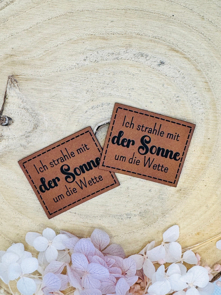 superweiches braunes Kunstlederlabel mit dem Spruch Ich strahle mit der Sonne um die Wette