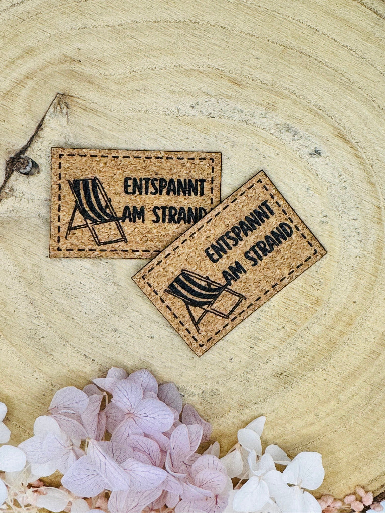 superweiches Kunstlederlabel in Kork Optik mit dem Spruch Enstpannt am Strand und einem abgebildeten Liegestuhl