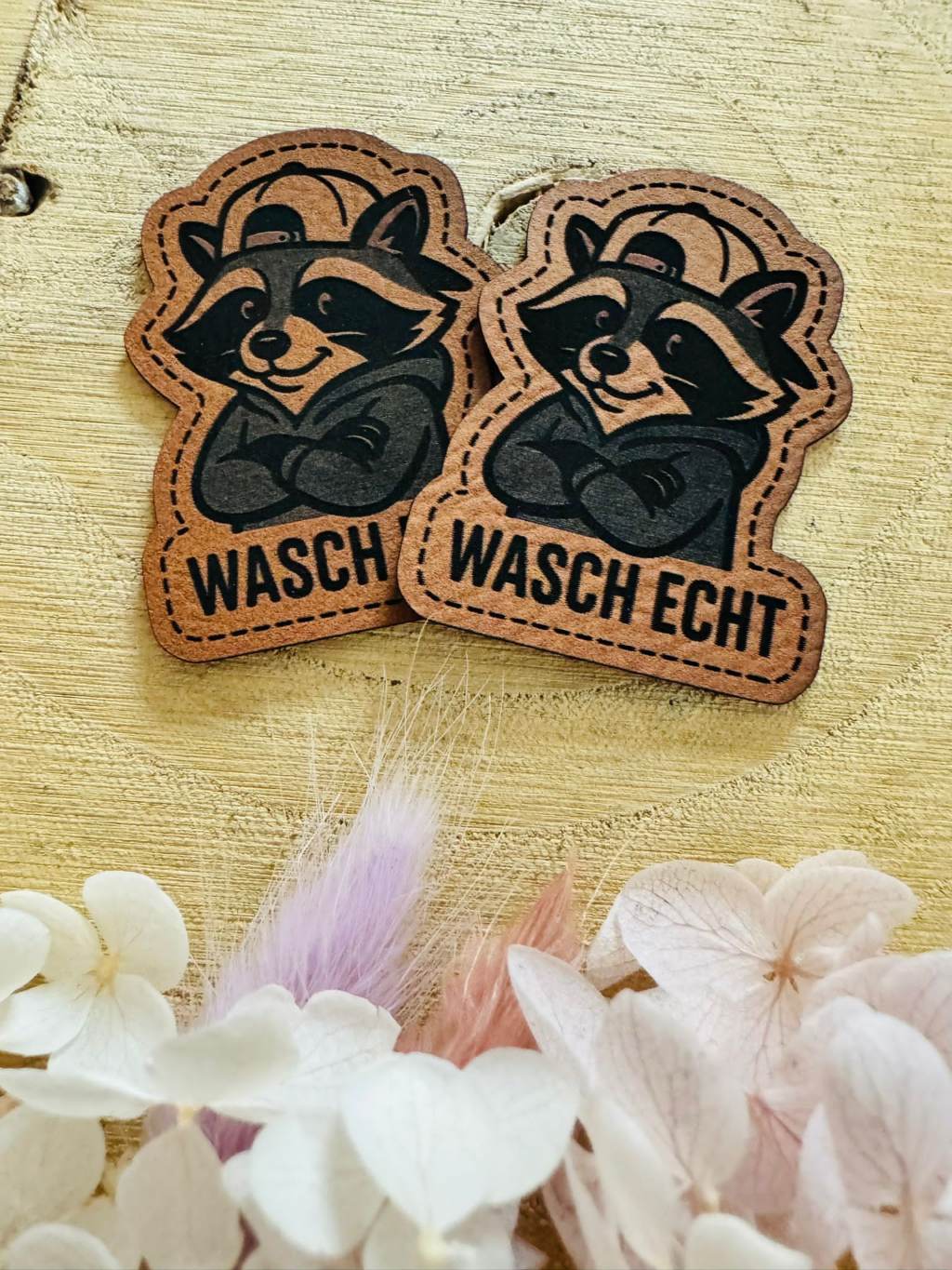 superweiches braunes Kontur Kunstleder Label mit einem kleinen pfiffigen Waschbär und dem Spruch Wasch Echt abgebildet
