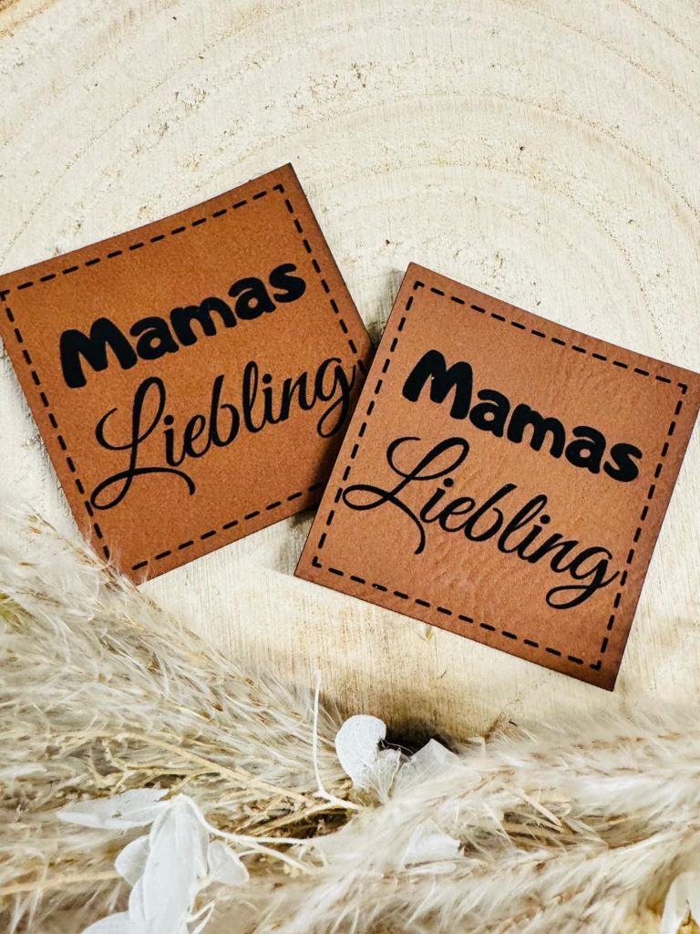 superweiches braunes Kunstlederlabel mit dem Spruch Mamas Liebling in schwarzer Schrift