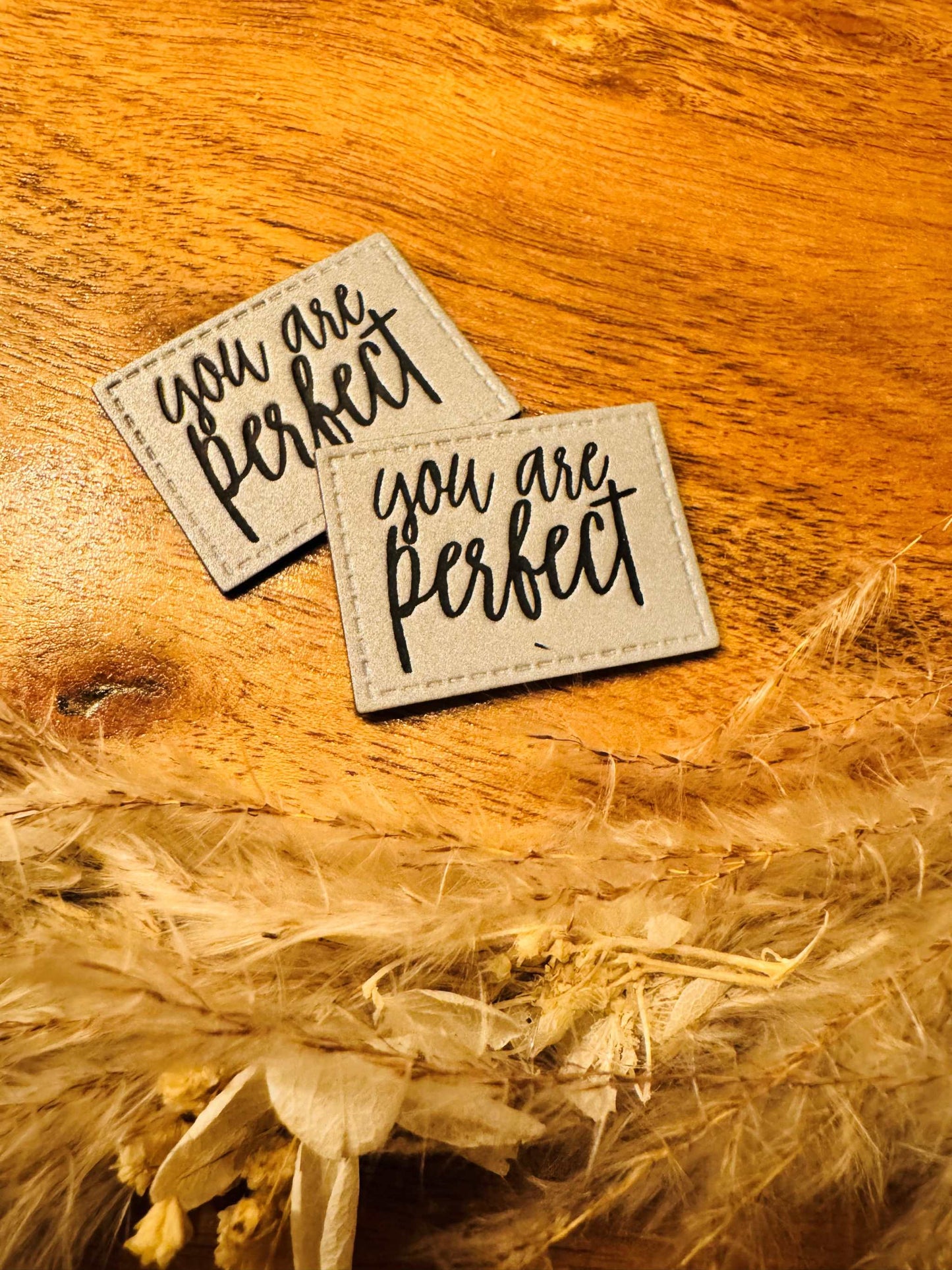 silber graues reflektierendes Kunstlederlabel mit dem Spruch You are perfect