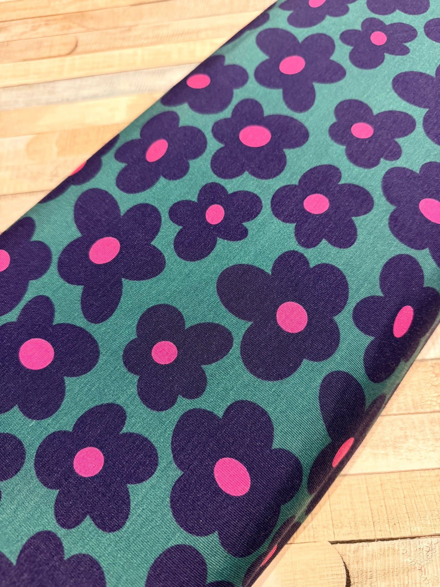 schöner Jersey Stoff mit pink/blauen Blumen auf grünem Untergrund