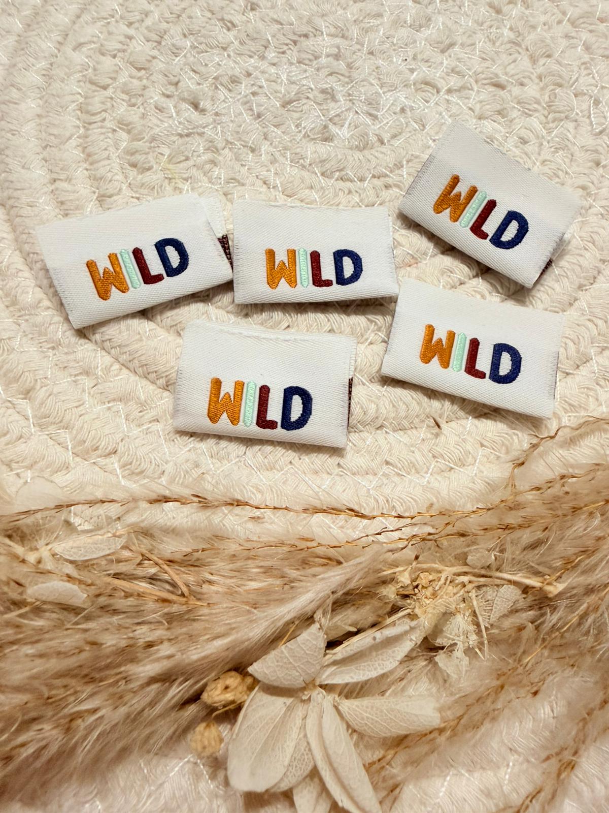 tolles weisses Weblabel von den Bienenkinder mit dem Spruch Wild in bunten Buchstaben