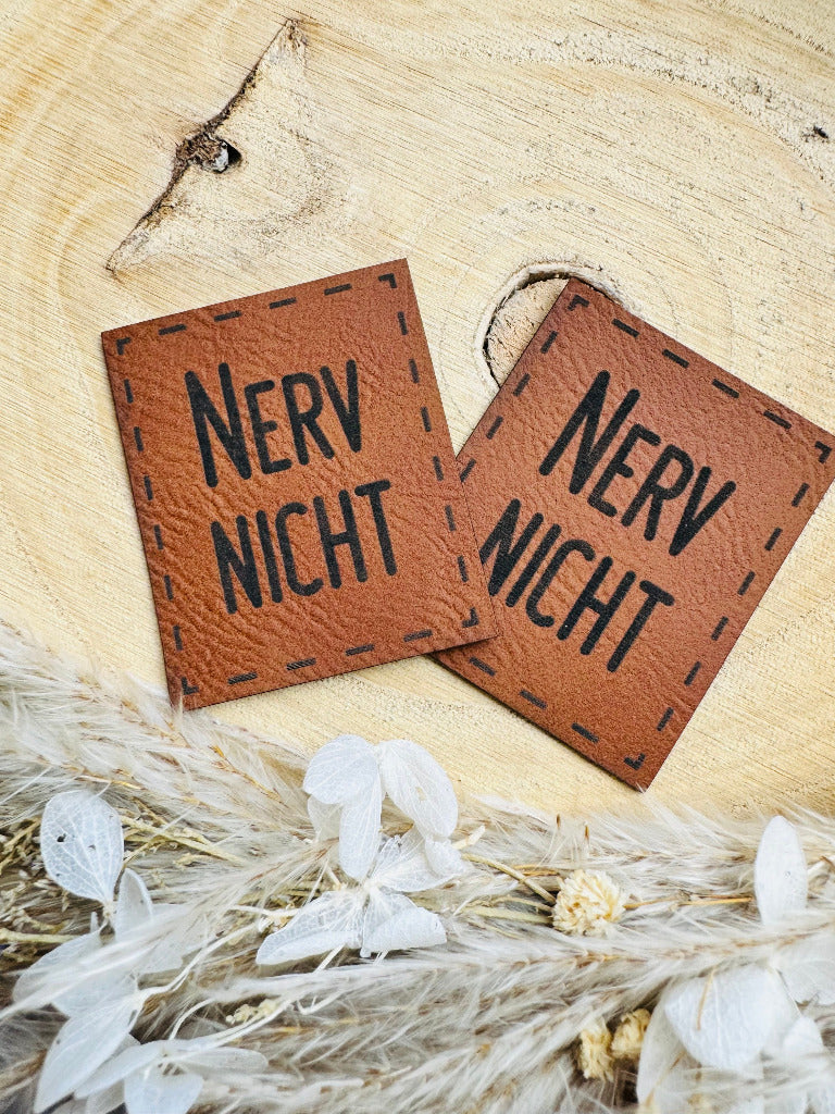 superweiches braunes Kunstlederlabel mit dem Spruch Nerv Nicht in schwarzen Buchstaben
