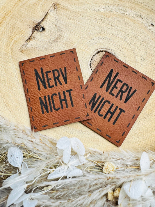 superweiches braunes Kunstlederlabel mit dem Spruch Nerv Nicht in schwarzen Buchstaben