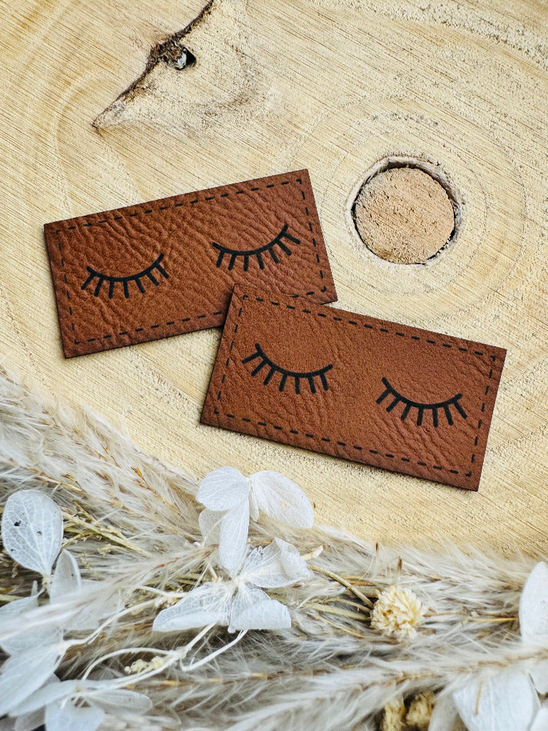 superweiches braunes Kunstlederlabel mit zwei geschlossenn Augenliedern in schwarz