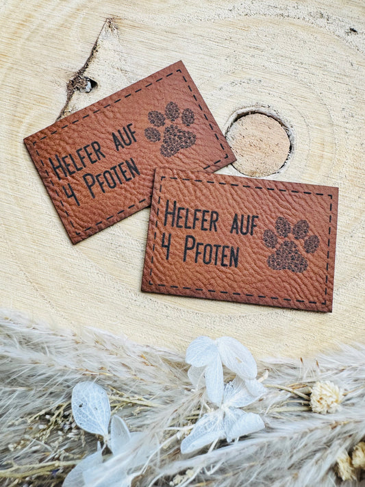 braunes Kunstlederlabel mit dem Spruch Helfer auf 4 Pfoten und einer Tatze abgebildet