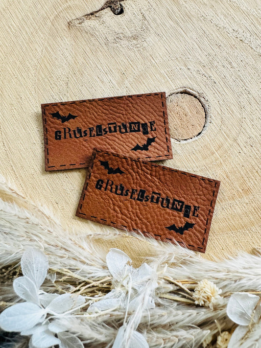 superweiches braunes Kunstleder Label mit dem Wort Gruselstunde und zwei kleinen Fledermäusen