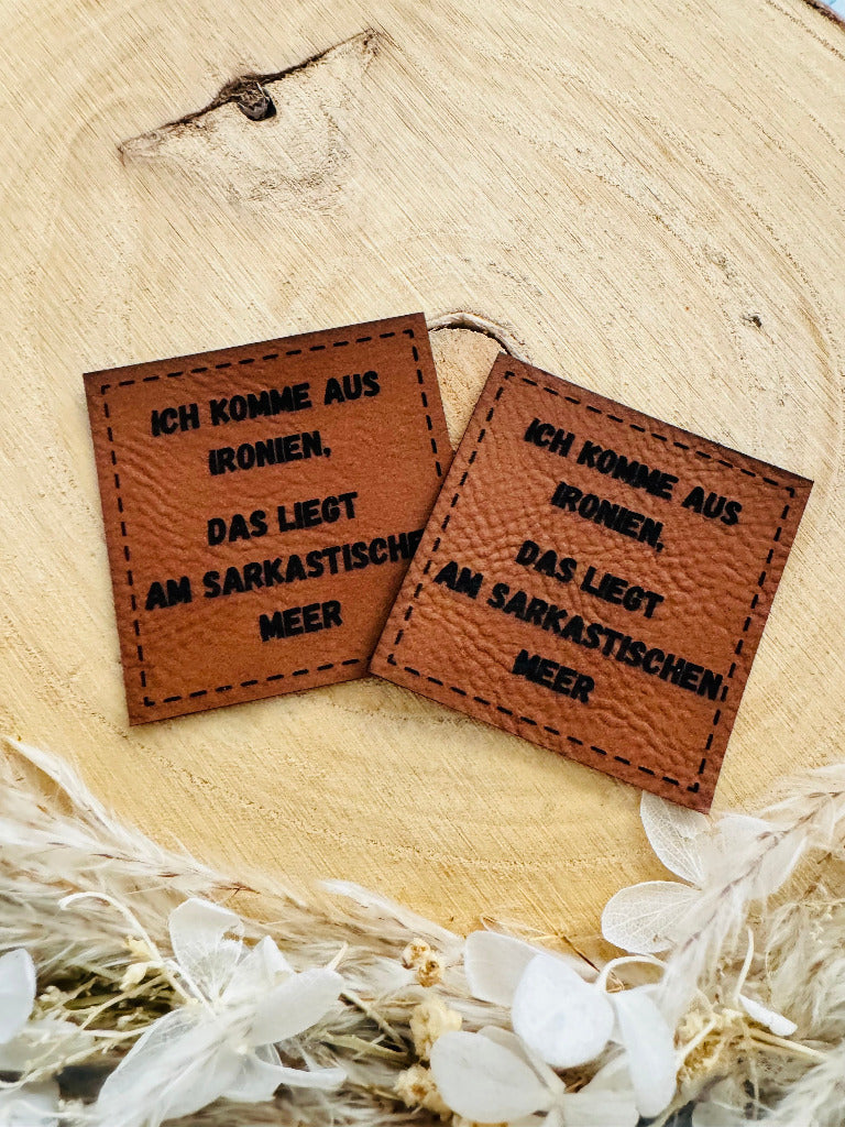 superweiches braunes Kunstlederlabel mit dem Spruch Ich komme aus Ironien, das liegt am sarkastischen Meer