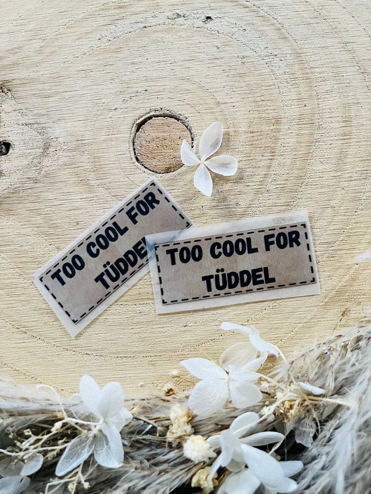 hellgraues Bügellabel mit dem Spruch Too cool for Tüddel 