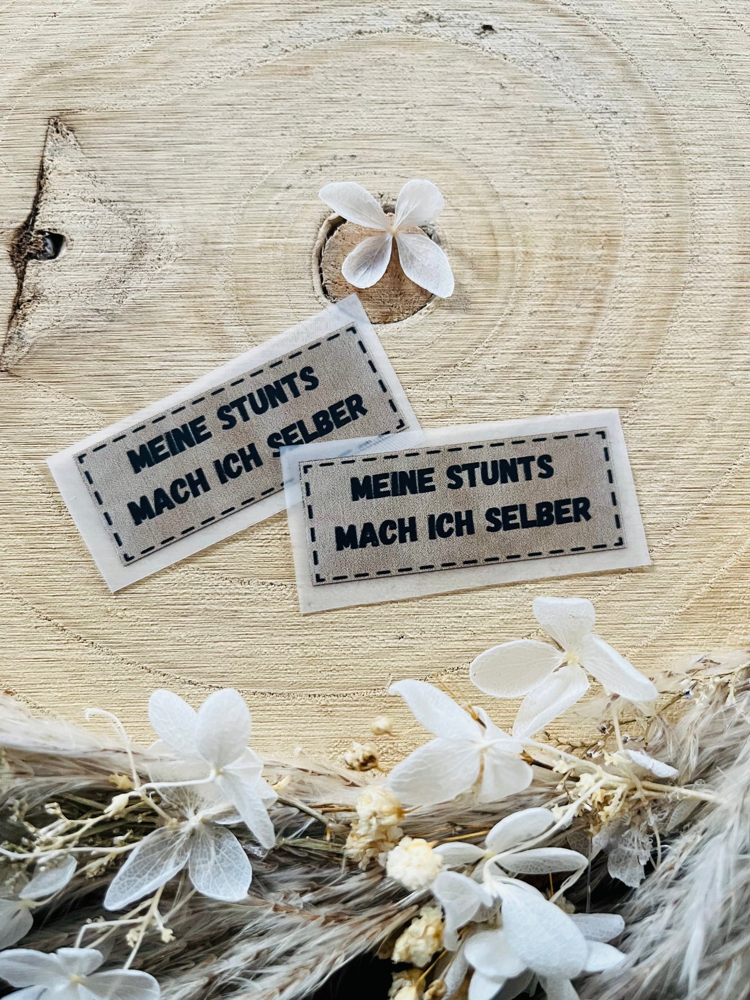 hellgraues Bügellabel mit dem Spruch Meine Stunts mach ich selber