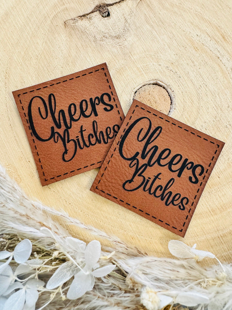 superweiches braunes Kunstlederlabel mit dem Spruch Cheers Bitches