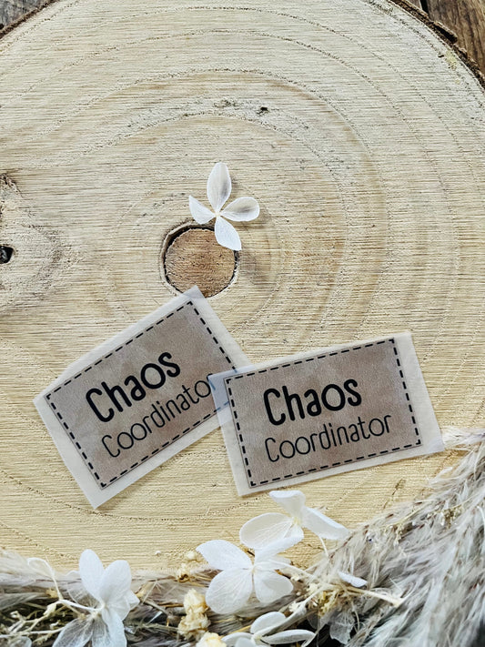 hellbraunes Bügellabel mit dem Spruch Chaos Coordinator in schwarzer Schrift