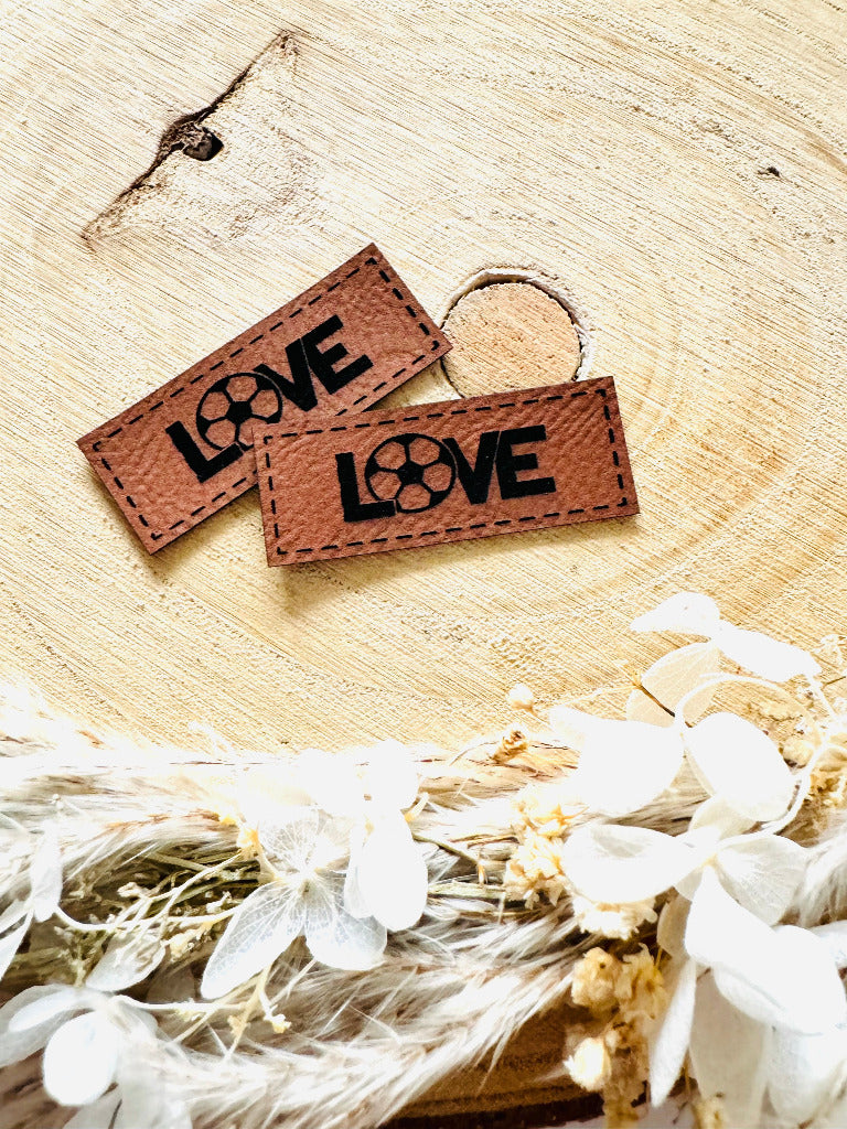 superweiches braunes Kunstlederlabel mit dem Spruch LOVE das O ist durch einen Fußball ersetzt