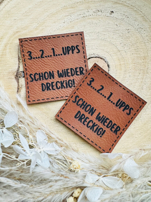 superweiches braunes Kunstlederlabel mit dem Spruch 3 2 1 Upps schon wieder dreckig
