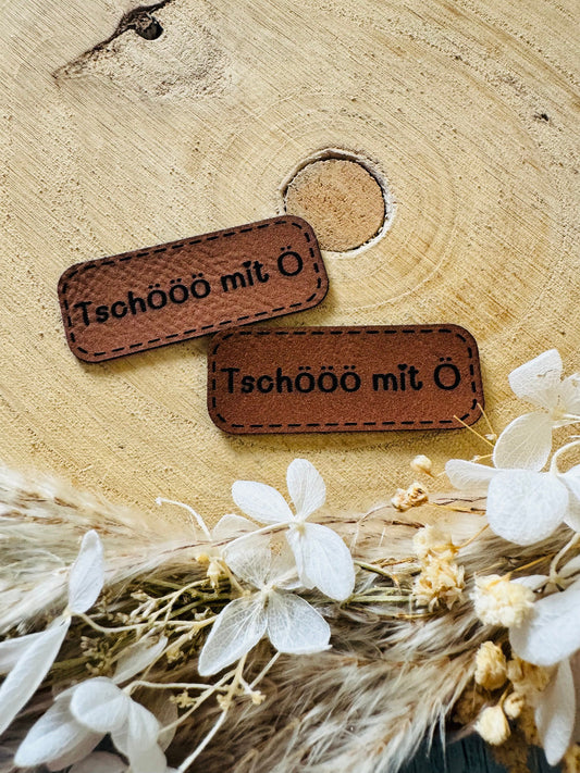 superweiches braunes Kunstlederlabel mit dem Spruch Tschööö mit Ö