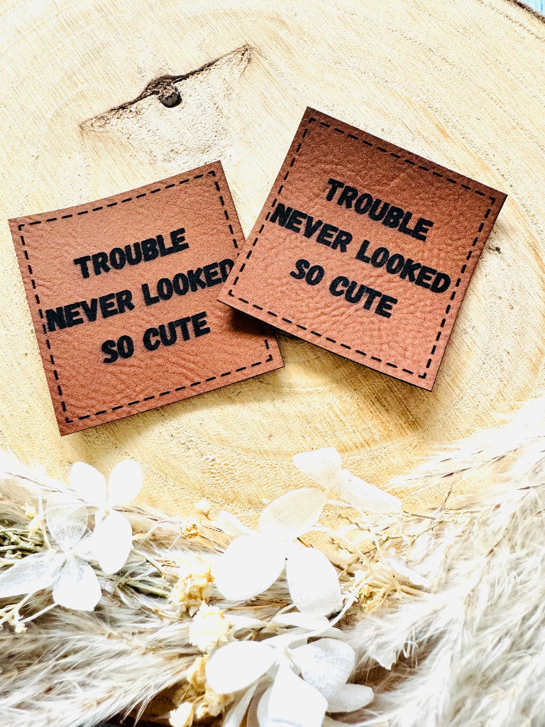 superweiches braunes Kunstlederlabel mit dem Spruch Trouble never looked so Cute