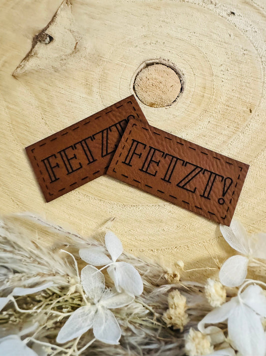 superweiches braunes Kunstlederlabel mit dem Wort FETZT Ausrufezeichen