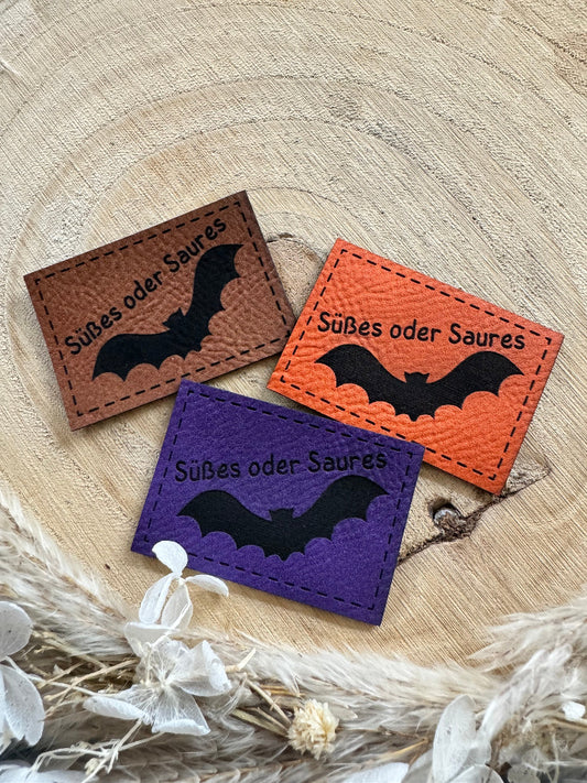 superweiche Kunstlederlabel in drei Farben mit dem Spruch Süßes oder Saures und einer fliegenden Federmaus