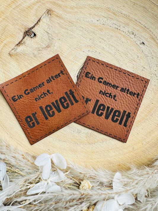 superweiches braunes Kunstlederlabel mit dem Spruch Ein Gamer altert nicht, er levelt