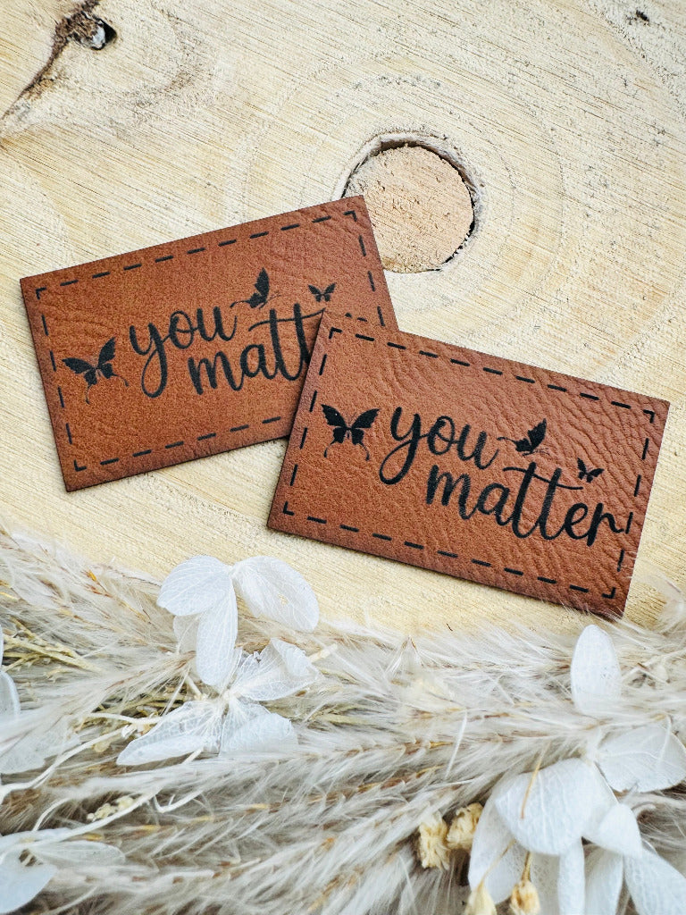 superweiches braunes Kunstlederlabel mit dem Spruch You matter mit Schmetterlingen abgebildet