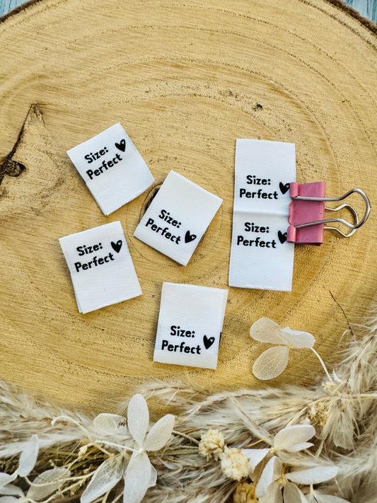 weisses Weblabel mit dem Spruch Size Doppelpunkt perfect in schwarzer Schrift mit einem kleinen Herzen