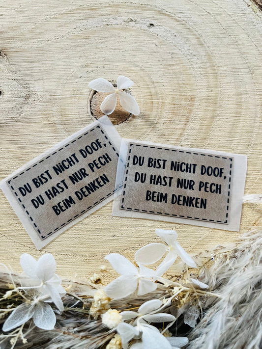 hellgraues Bügellabel mit dem Spruch Du bist nicht doof, du hast nur pech beim denken