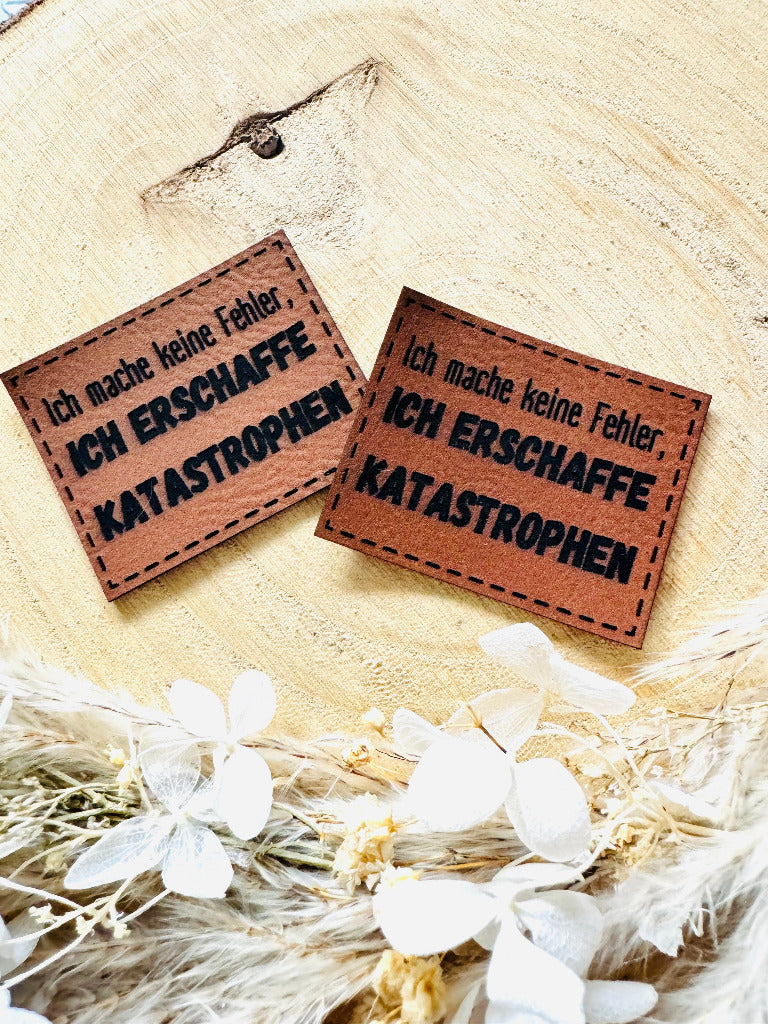 superweiches braunes Kunstlederlabel mit dem Spruch Ich mache keine Fehler Komma ICH ERSCHAFFE KATASTROPHEN 
