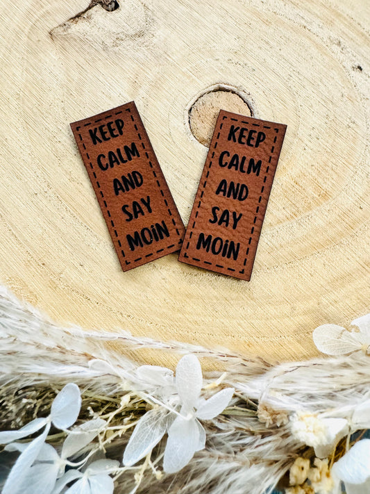 braunes Kunstlederlabel mit dem Spruch Keep Calm and say Moin