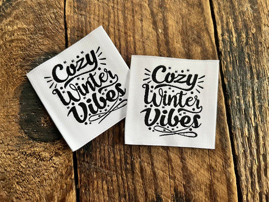 weisses Weblabel mit dem Spruch Cozy Winter Vibes in geschwungener schwarzer Schrift