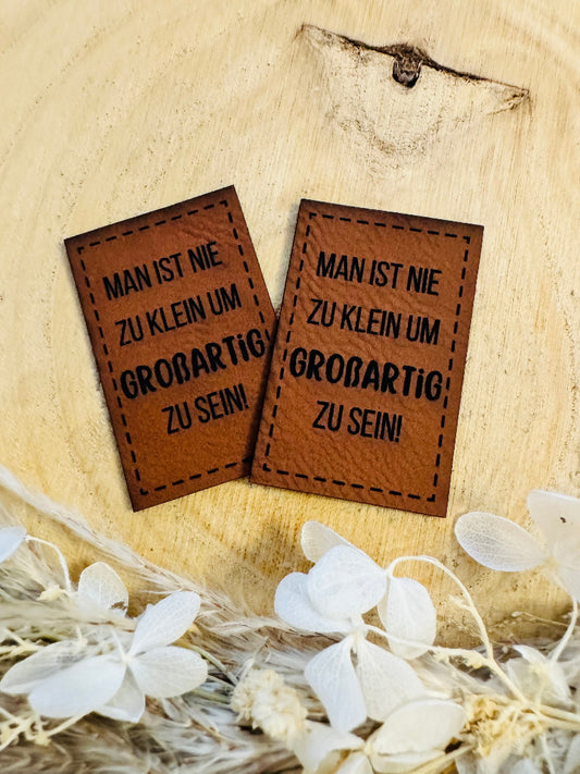 superweiches braunes Kunstlederlabel mit dem Spruch Man ist nie zu klein, um Großartig zu sein Ausrufezeichen
