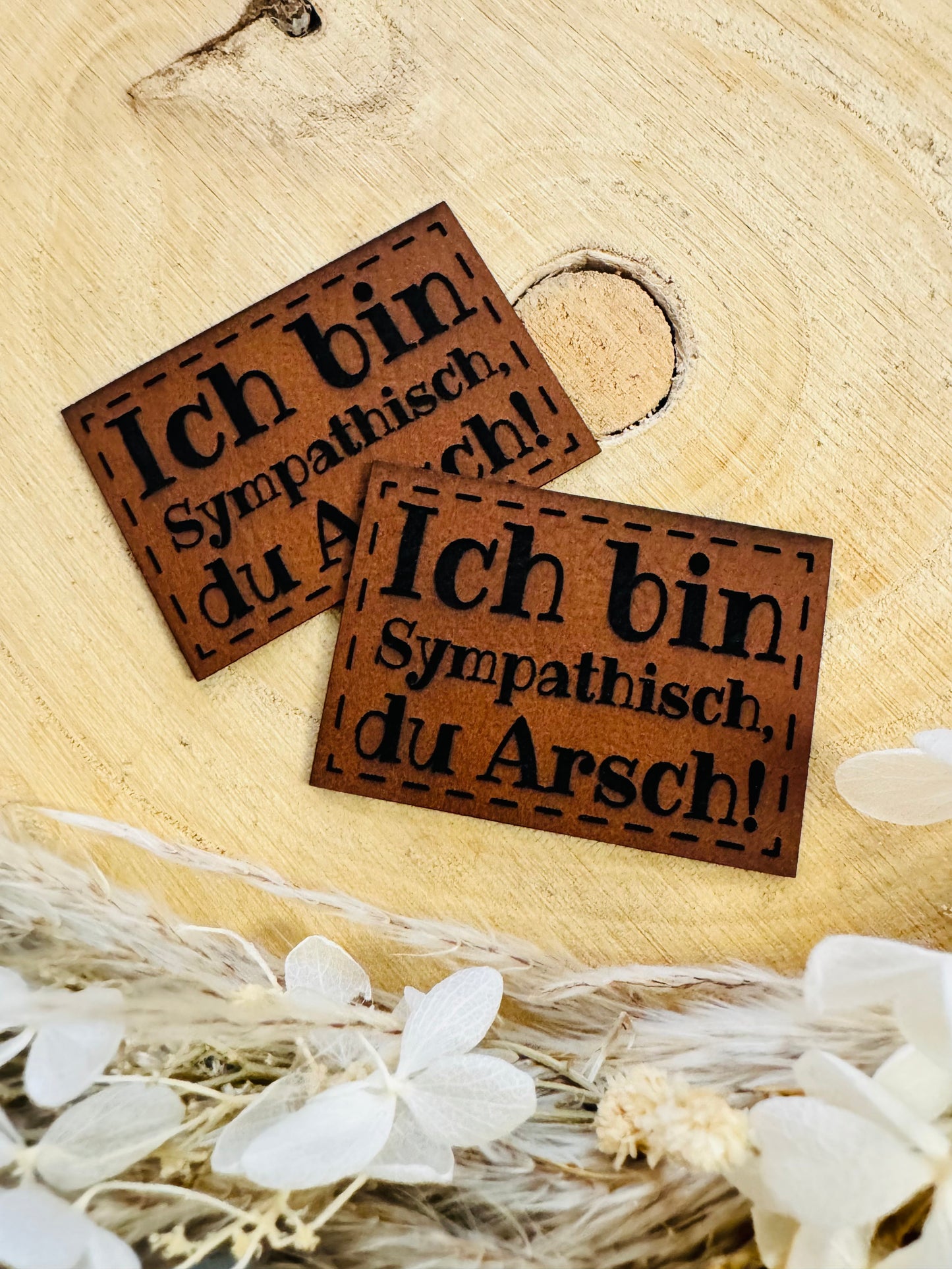 braunes Kunstlederlabel mit dem pruch Ich bin sympatisch du Arsch Ausrufezeichen