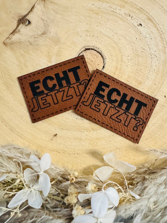 superweiches braunes Kunstlederlabel mit dem Spruch Echt Jetzt Fragezeichen