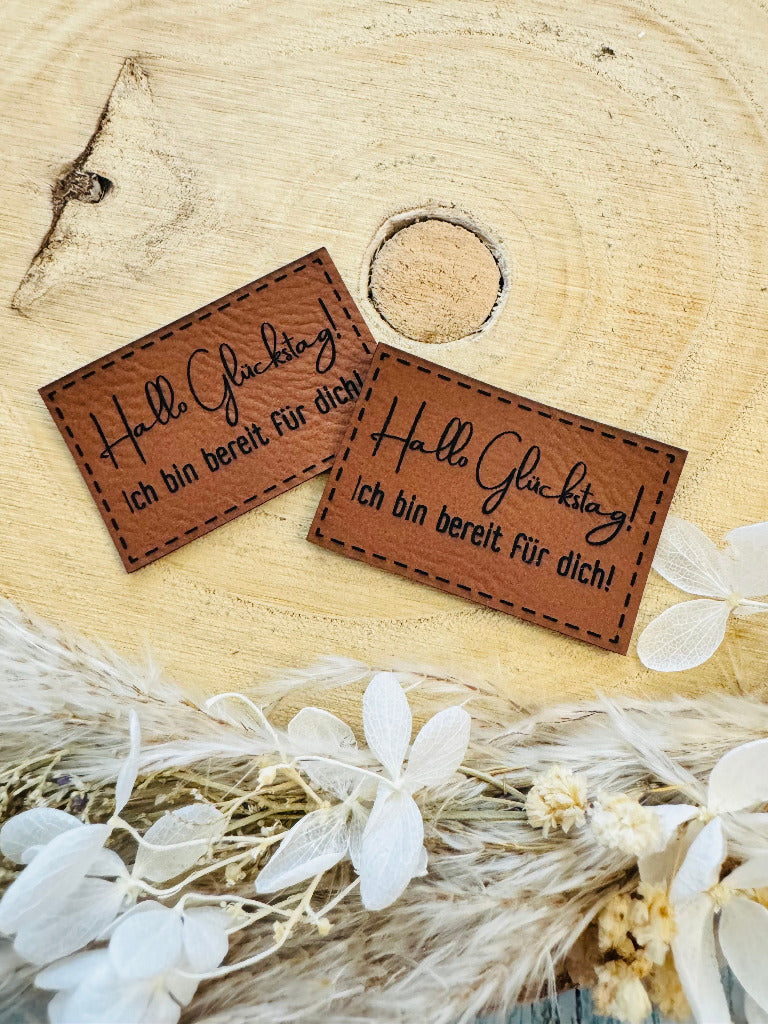 superweiches braunes Kunstlederlabel mit dem Spruch Hallo Glückstag Ausrufezeichen ich bin bereit für Dich Ausrufezeichen