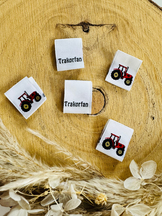 weisses Weblabel mit auf einer Seite der Spruch Traktorfan und auf der anderen Seite ist ein roter Traktor abgebildet
