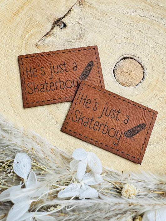 superweiches braunes Kunstlederlabel mit dem Spruch He`s just a katerboy mit einem kleinen Skateboard abgebildet