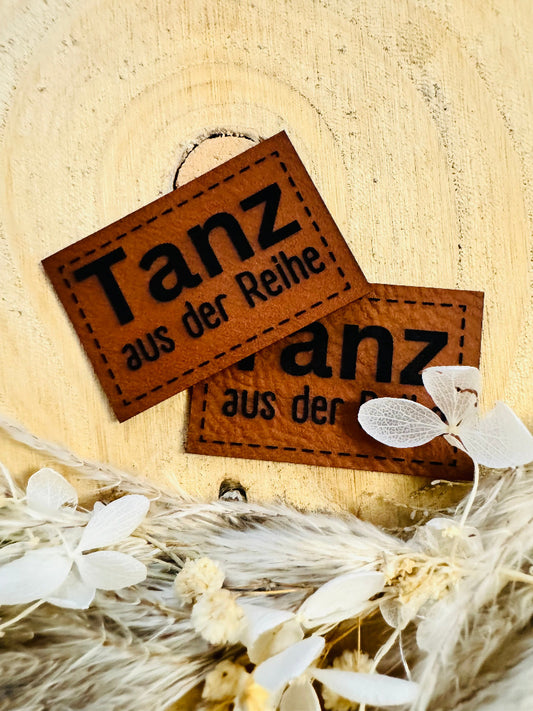 superweiches braunes Kunstlederlabel mit dem Spruch TANZ aus der Reihe