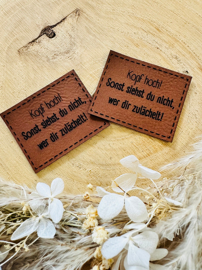 superweiches braunes Kunstlederlabel mit dem Spruch Kopf hoch Ausrufezeichen Sonst siehst du nicht Komma wer dir zulächelt Ausrufezeichen