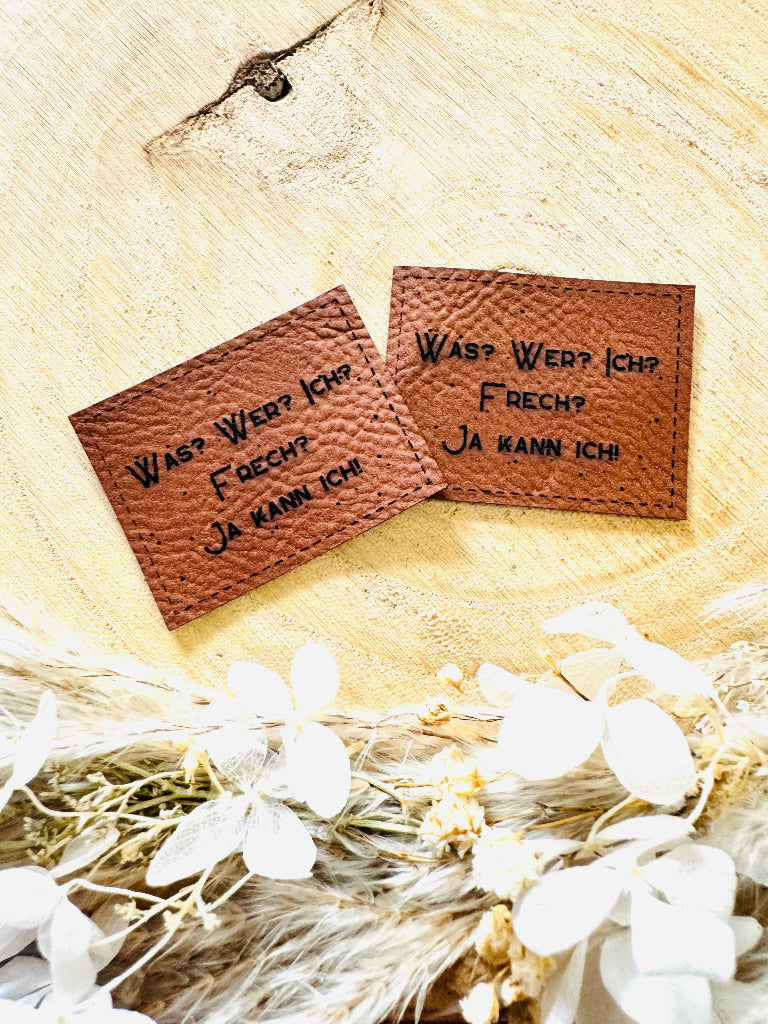 superweiches braunes Kunstlederlabel mit dem Spruch Was Fragezeichen Wer Fragezeichen Ich Fragezeichen Frech Fragezeichen Ja kann Ich Ausrufezeichen