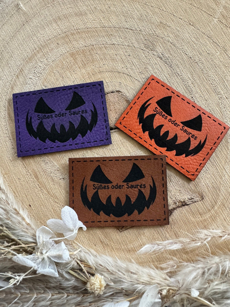 superweiche Kunstlederlabel in drei Farben mit dem Spruch Suesses oder Saures und einem Halloween Gesicht