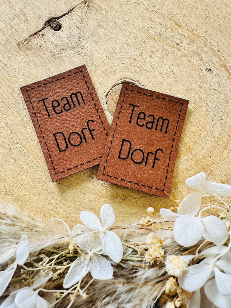 superweiches braunes Kunstlederlabel mit dem Spruch TEAM DORF