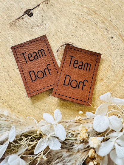 superweiches braunes Kunstlederlabel mit dem Spruch TEAM DORF