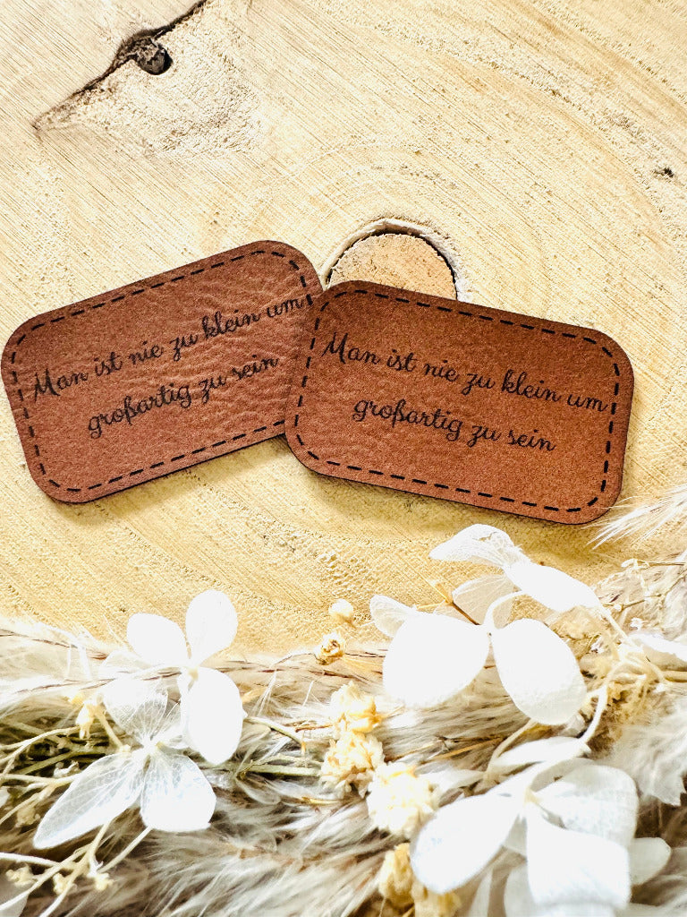 superweiches braunes Kunstlederlabel mit dem Spruch Man ist nie zu klein um großartig zu sein in schwarzer Schrift