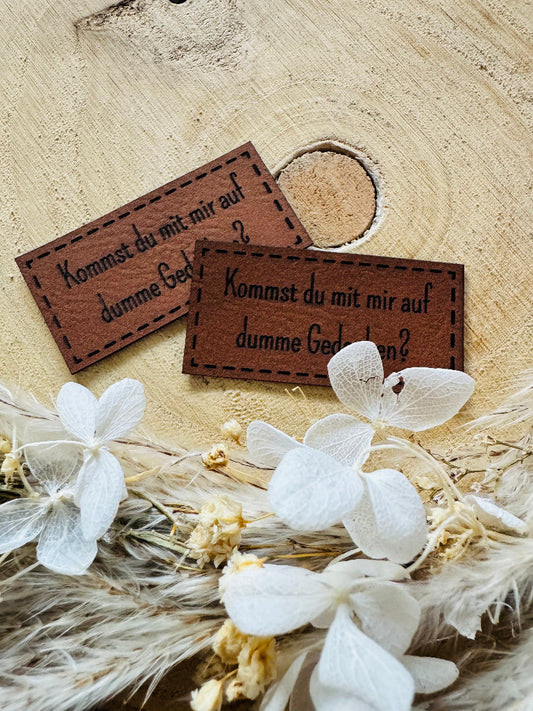 superweiches braunes Kunstlederlabel mit dem Spruch Kommst du mit mir auf dumme Gedanken Fragezeichen
